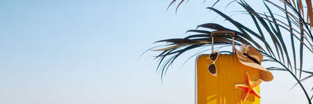Yellow travel luggage with summer accessory under the palm tree on clear blue sky background 3D Rendering, 3D Illustrationの写真素材