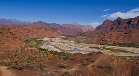 River flowing down from the mountains and eroded mountains forming broad valleysの写真素材