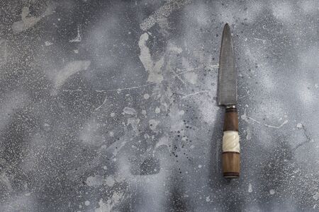 vintage kitchen knife with a wooden handle on a rustic table from old boards, top view, close up