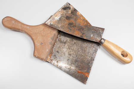 two old painters spatula with rust and use marks with wooden handle on white backgroundの写真素材