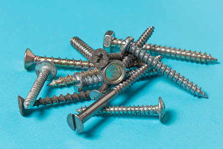 Gloved hand of worker tightens screw nut with adjustable metal wrench or french wrench in wooden...