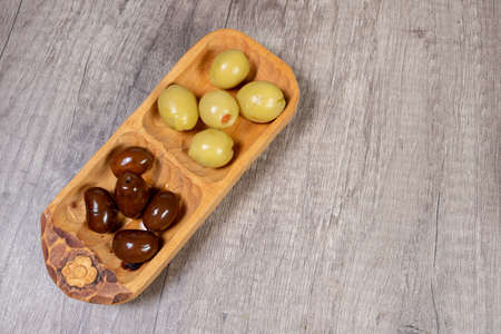 black and green olives with olive branch on a wooden board. Top Viewの写真素材