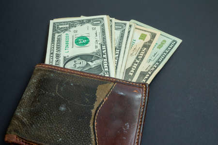 Used green and leather wallet with american dollars bils isolated on black background