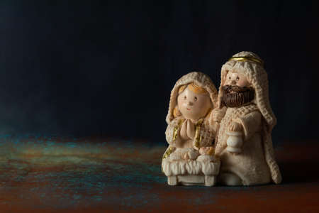 Representation of a Christmas nativity scene with the small figures of baby Jesus, Mary and Joseph on a rock background. Phrase space on the left. Christmas concept.の写真素材