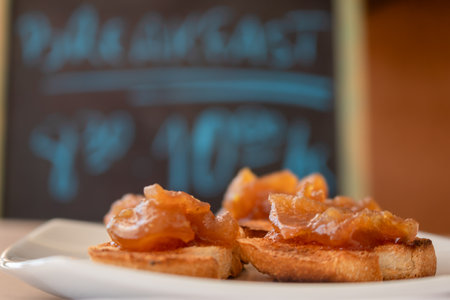 Homemade bread toast with a delicious homemade apple and onion chutney, with cinnamon on a light wooden board. Perfect jam for breakfast.の写真素材