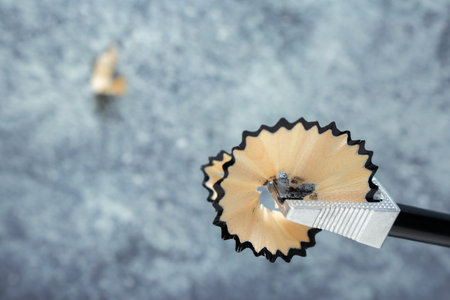 Action of sharpening a pencil with a standard sharpener. Wood residues that form the pencilの写真素材