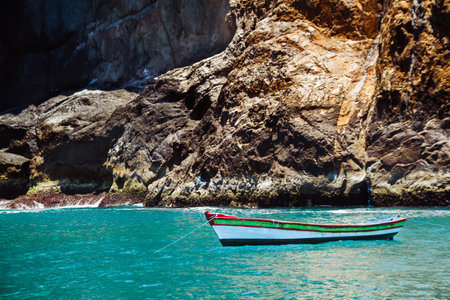 Lonely and small boat of a fisherman on the coast of the transparent tropical sea. Brazil.の写真素材