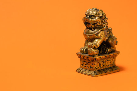 Lion sculpture of Chinese culture. Very popular Chinese decorative and religious ornament. Orange background.の写真素材