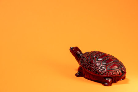 Small sculpture of a terra cotta colored African tortoise walking.の写真素材