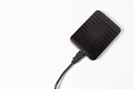 External hard drive or hard disk with USB cable on white background.