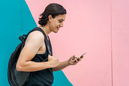Young latin man smiling happy reading message on the smartphone. Concept communication.