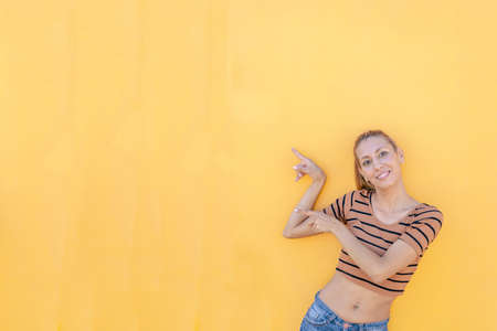 Funny Latin woman pointing to an empty space to put a text or image. Marketing conceptの写真素材