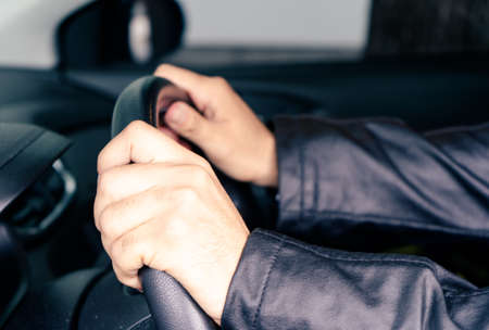 Hands taking the wheel of a car. Transportation and success concept.の写真素材