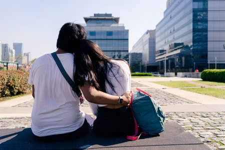 Couple of young man and woman sitting on a bench and embracing. concept romanticism.