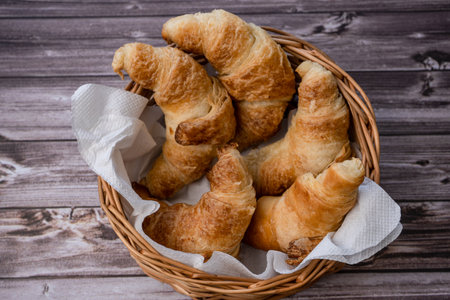 Croissants in a pan or bread basket and Croissants parts and crumbs on the table.の写真素材