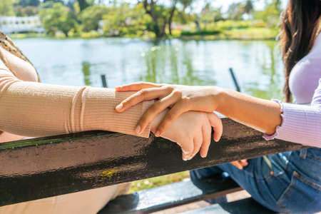 Young ladies holding hands showing their feelings.の写真素材