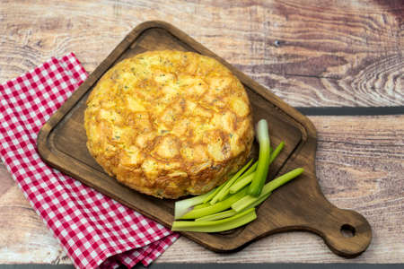 Homemade potato or potato omelette on a wooden board on a rustic table. Natural and typical Spanish food. Regional cuisine concept.の写真素材