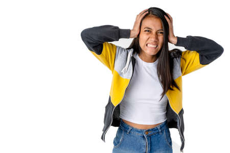 Attractive Latin woman holding her head with an angry expression on a pure white background.の写真素材