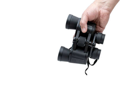 A man's hand holding a pair of binoculars on white background.