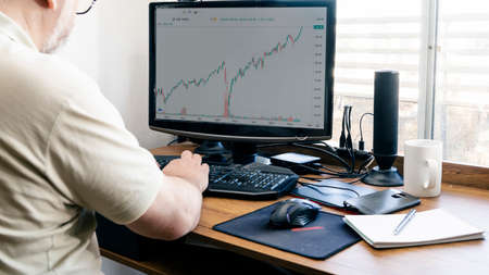 Working at home with a desktop computer, man typing. One Male hand on the keyboard and the other on...