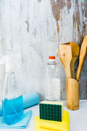 Different household cleaning items on a marble countertop in a kitchen. Vertical orientation, normal view. Home hygiene concept, fight against COVID-19, disinfection.の写真素材