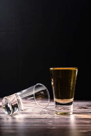 Normal view with vertical orientation of a shot of whiskey or scotch next to a second shot. text space.の写真素材