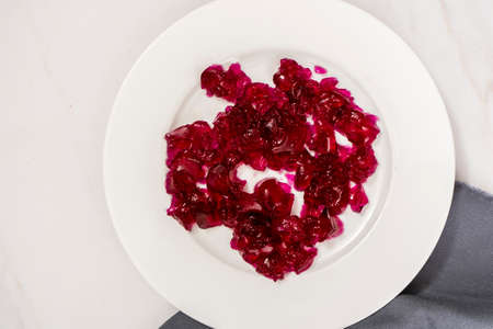 Raspberry jelly on a white plate. Copy space.