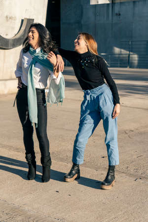Full shot of two beautiful women friends while smiling. Friendship concept.の写真素材
