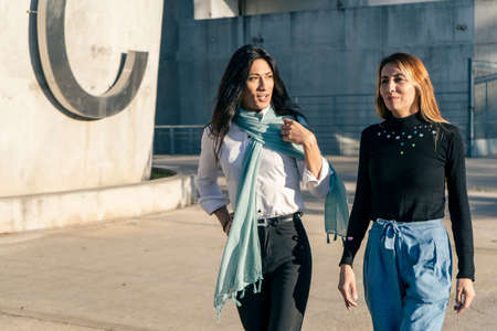 Close-up American shot of two beautiful women friends as they walk and talk. Friendship and joy...