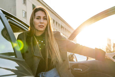 Beautiful Latin business woman getting out of her car.の写真素材