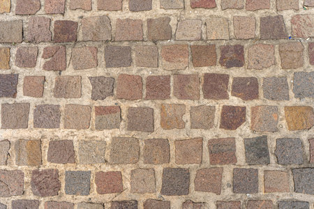 Old road paved with granite stones. Texture antique.