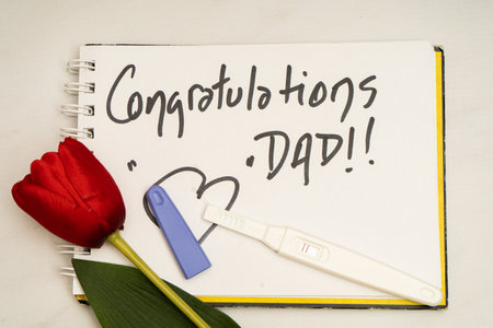 Pregnancy test. Device for evaluating pregnancy in women on a note congratulating the father. Positive pregnancy resultの写真素材