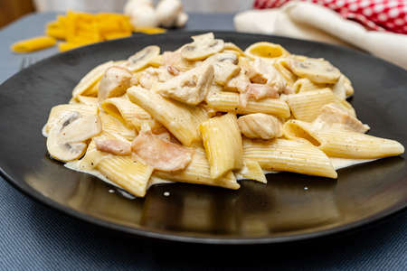 Pasta Penne with cream, jam, Chicken and Mushroom under Parmesan Cheeseの写真素材
