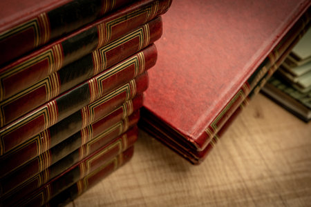Messy stacked old books on an old wooden table and dim light. Selective focus. Vintage scene concept. copy spaceの写真素材
