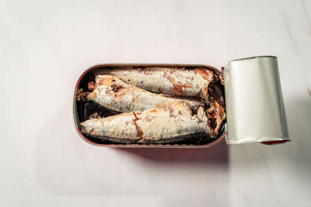 Open can of sardines in oil isolated on white simile marble surface. Marine food productの写真素材