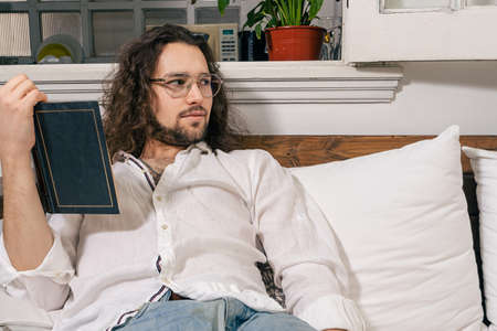 Man reading a book on a sofa