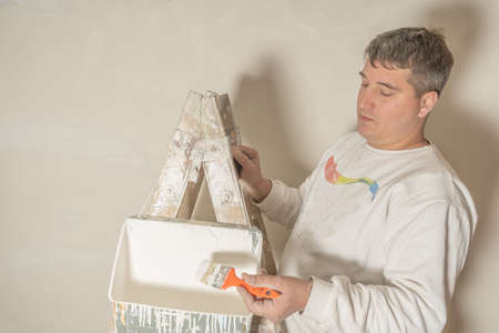 Young male painter using a brush to paint the details of a ceiling.の写真素材