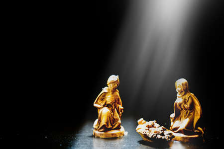 one Christmas nativity scene illuminated with direct light on the figures with a black background...