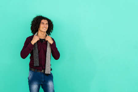 An American shot of a young latino man smiling with a light green backgroundの写真素材