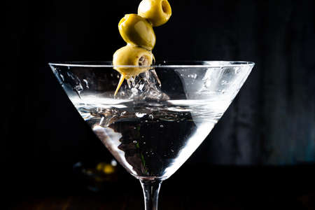 Scooping the olives out of the dry martini glass. portrait orientation,の写真素材