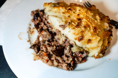 A slice of traditional potato pie or shepherd's pie made with meat and topped with potatoes. Homemade traditional cake. High view.の写真素材