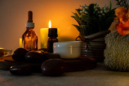 A Beauty and relaxation treatment in a spa. Essential oils, massage stones, creams on a light table...