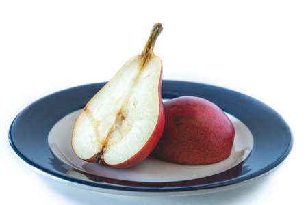 High view of a red battle pear cut in half on a plate. Organic and natural products, healthy food.の写真素材