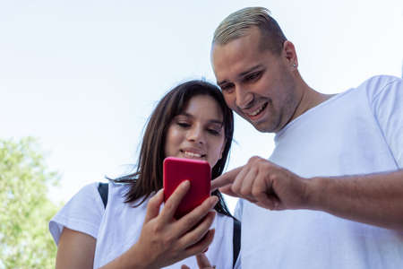 Close-up of a young Latin couple checking messages on their cell phone. concept couple, love, technology, communications.の写真素材