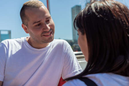 Close-up of a young couple talking romantically during a date outdoors.