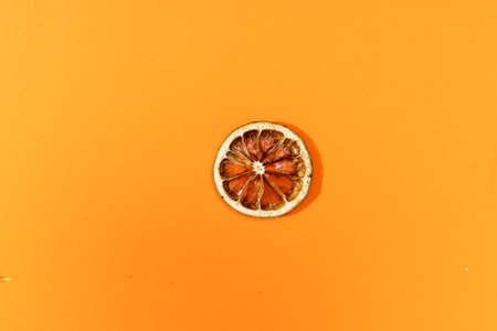 A Dissected orange slice on an orange surface.の写真素材
