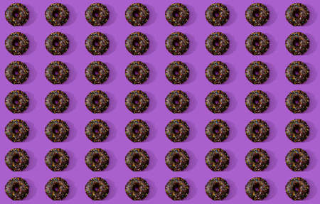 A mosaic-like arrangement of donuts on a purple surface.の写真素材