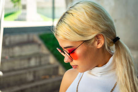 A Close-up of a beautiful young Latina woman with a worried face, wearing a white t-shirt and red...