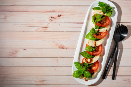 Classic Italian caprese salad of mozzarella, tomato and basil with olive oil and vinegar.の写真素材