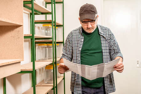 A foreman or worker checking a list of tasks or products in an empty warehouse. Concept of work.